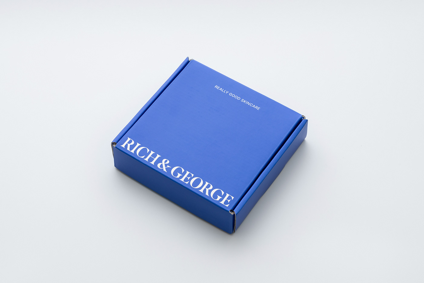 Blue mailer box with white serif font branding on the exterior