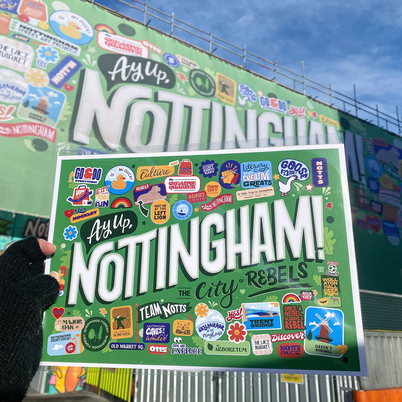 Nottingham Print with landmarks, locations and sayings held up in front of a large scale version.