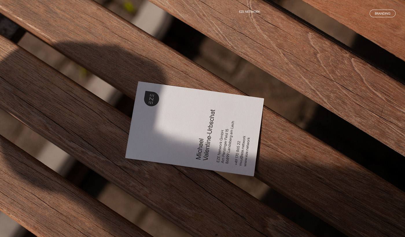 Simple and clean, black and white eze network business card laying on a wooden chair