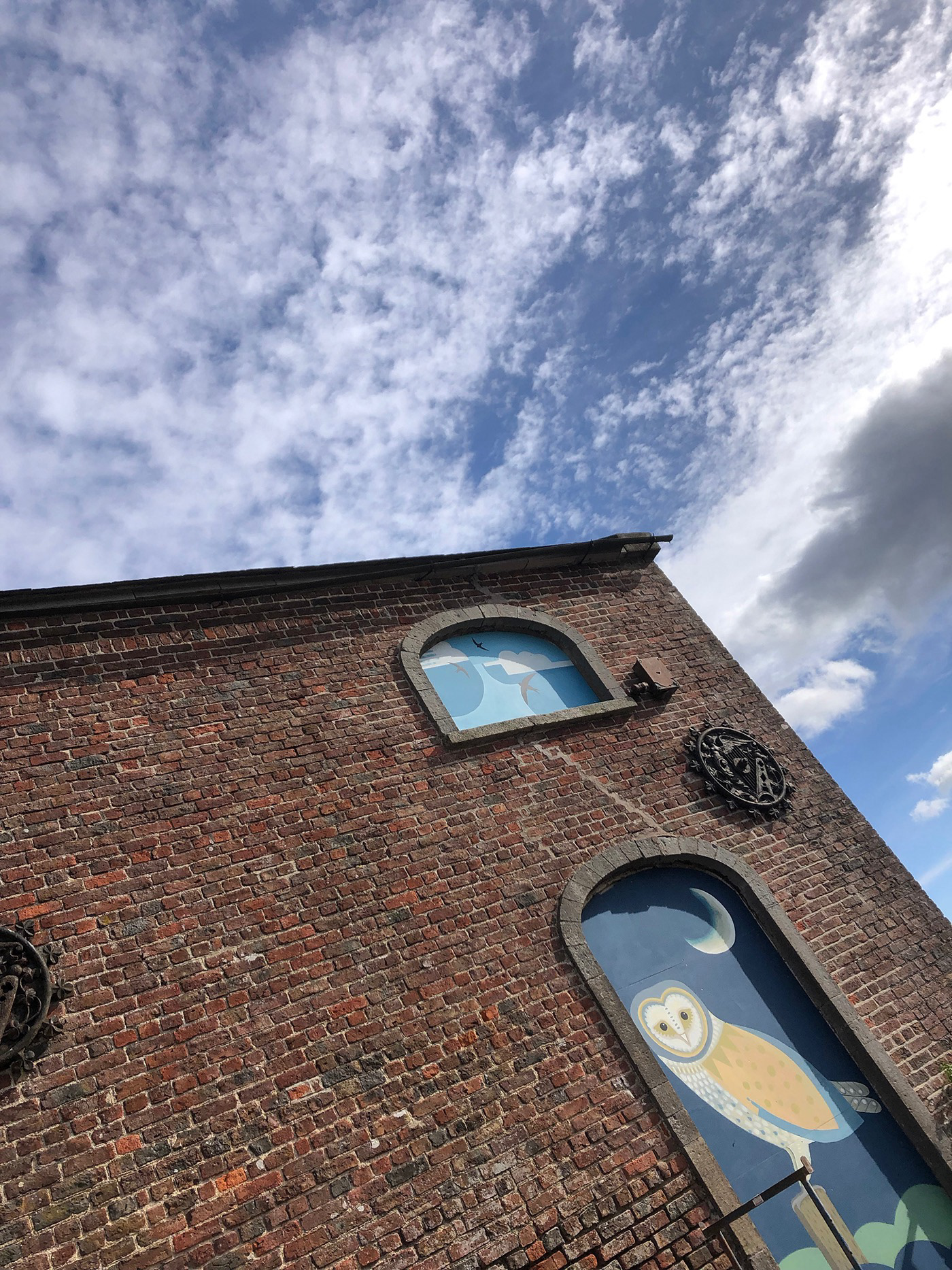 Swift and barn owl illustrations on outdoor panels for a heritage building