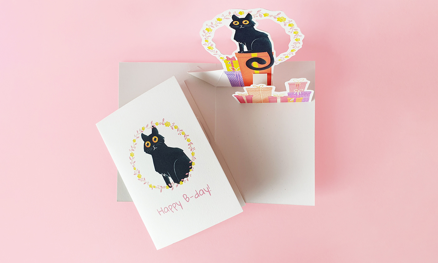 Image shows pop-up 3d black cat sitting on a presents. This is gift card.