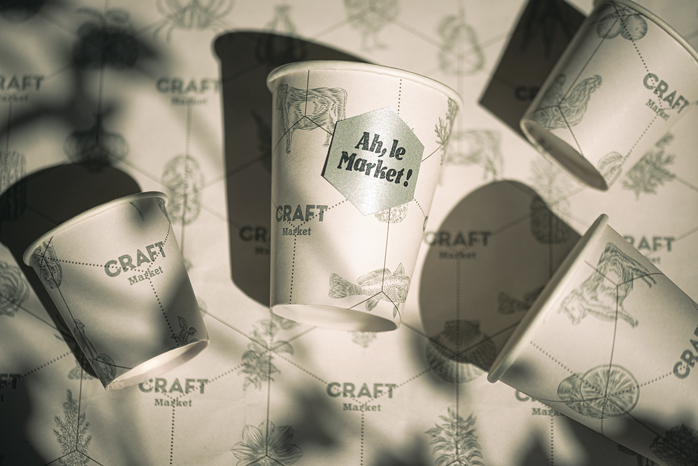 Closeup of CRAFT Market paper coffee coups with Toile de Jouy pattern.