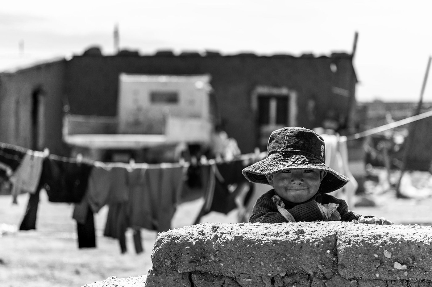 Black and white portrait of smiling child in Bolivia taken by travel photographer Jennifer Esseiva.