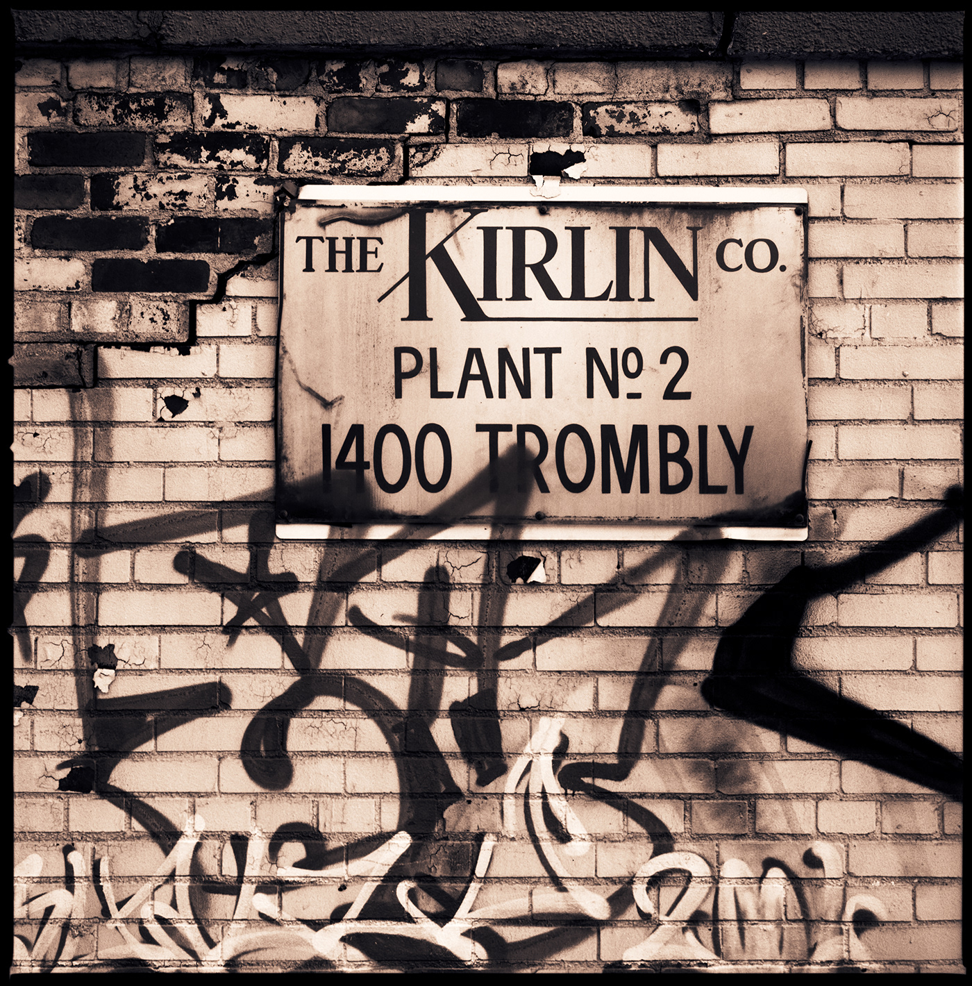 The Kirlin Co. sign on a wall with graffiti, in Detroit, Michigan.