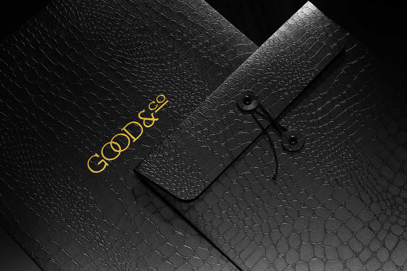 2 black envelopes with all over reptile texture and gold logo detailing