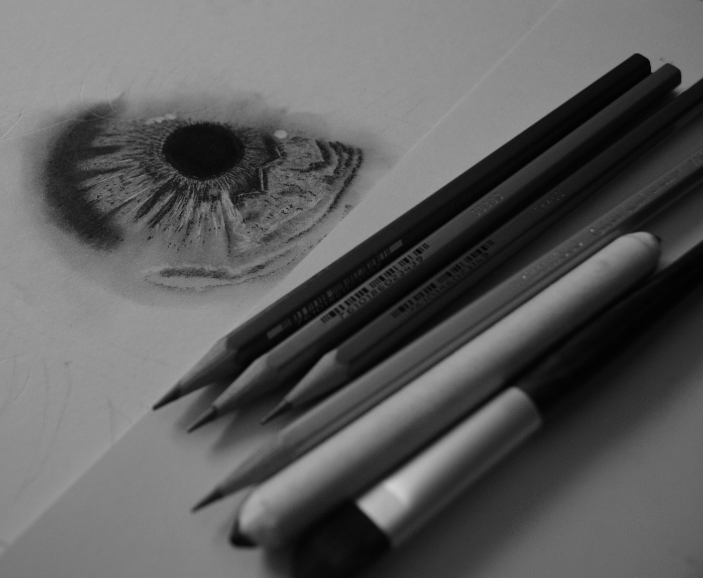 Drawing of a human eye made with graphite, charcoal and pastel mediums.