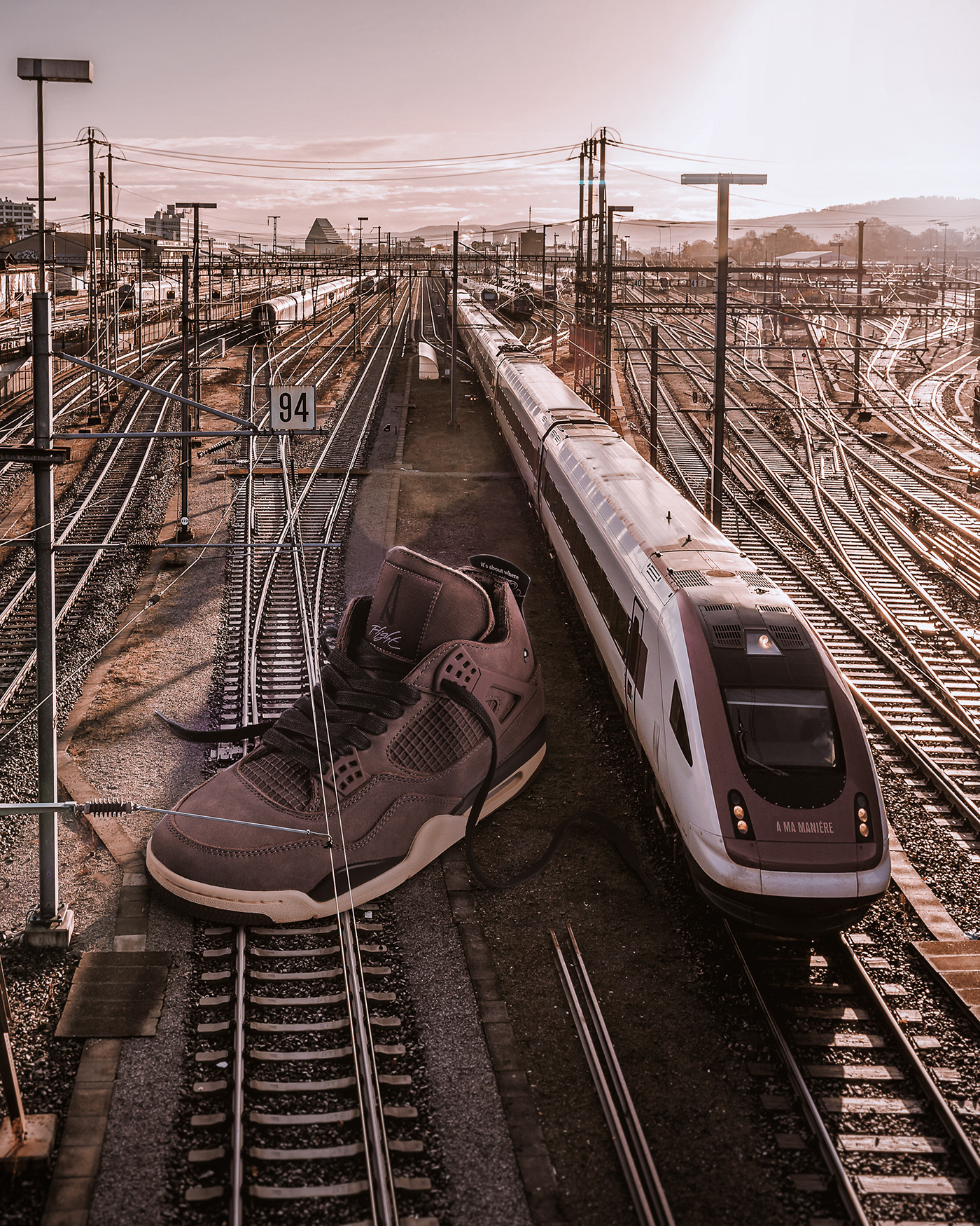 Giant sneaker photo composite on a train track . Retouching using Photoshop