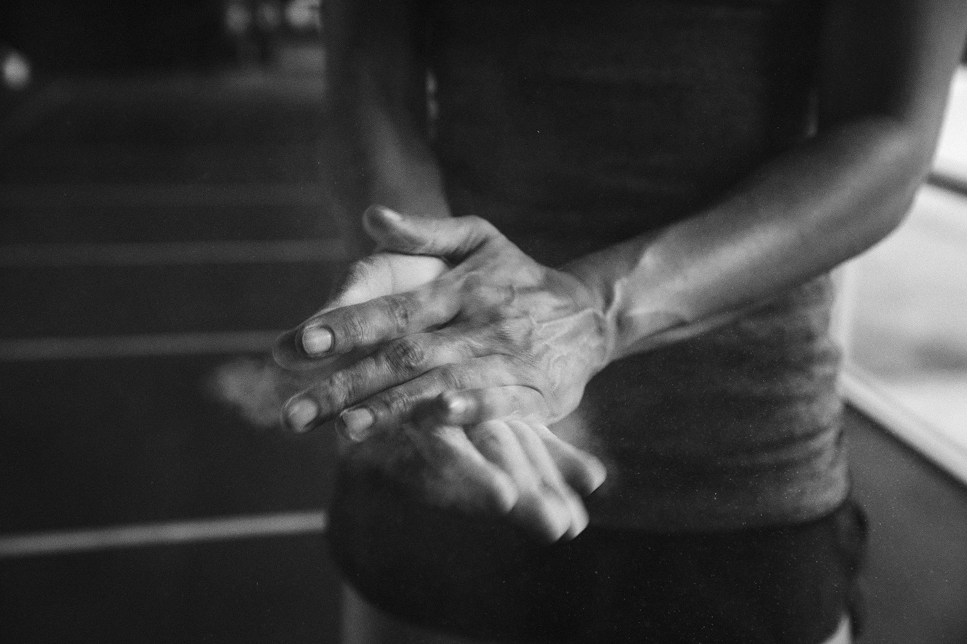 Female athlete using chalk on her hands. Black and White photography.