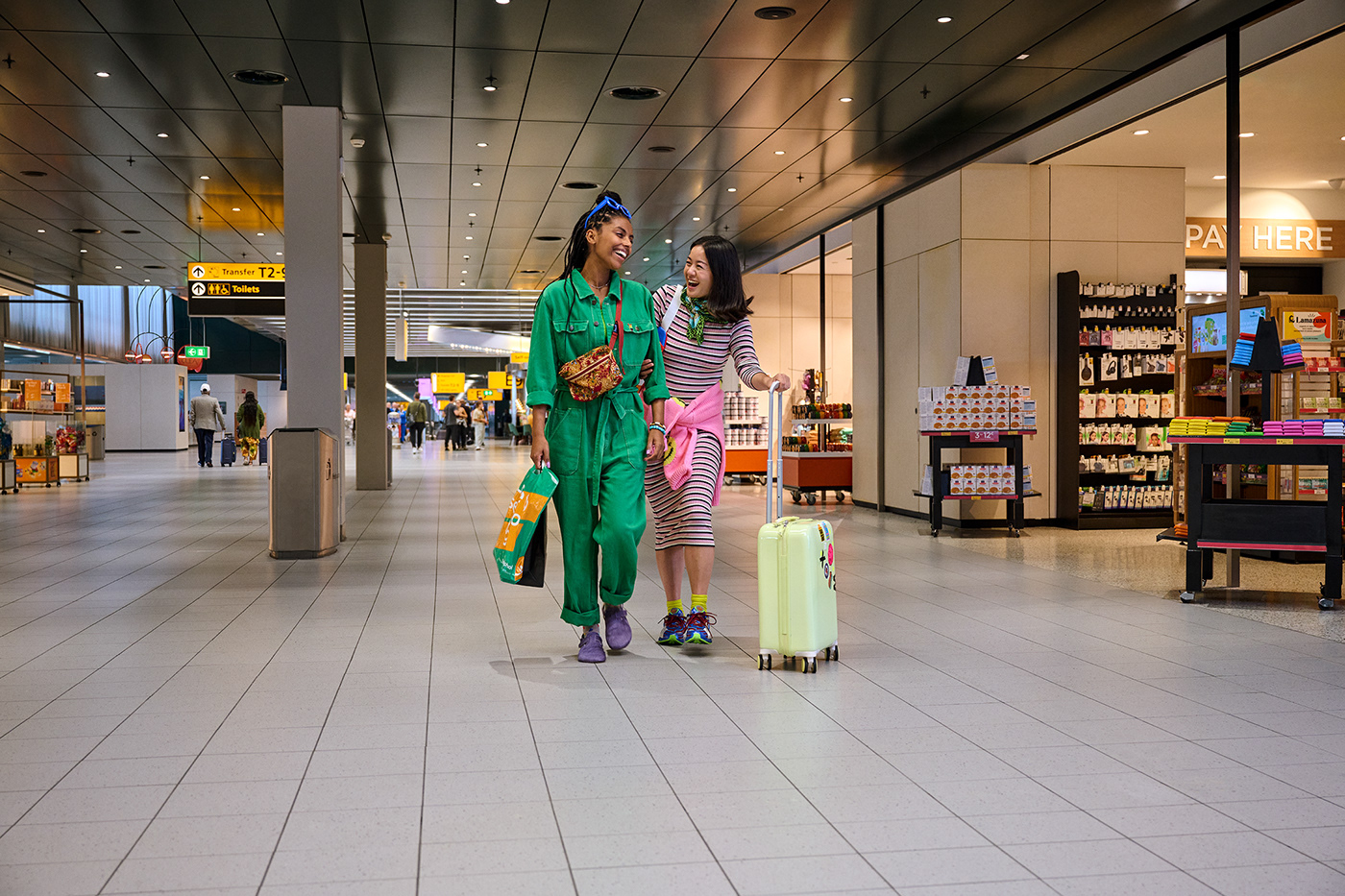 Two best friends are having fun while shopping on the airport together.