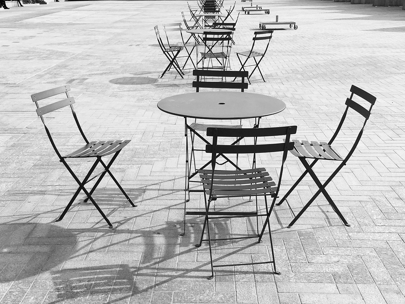 Outdoor black and white street photography Urban Street city tables chairs lines tables and chairs