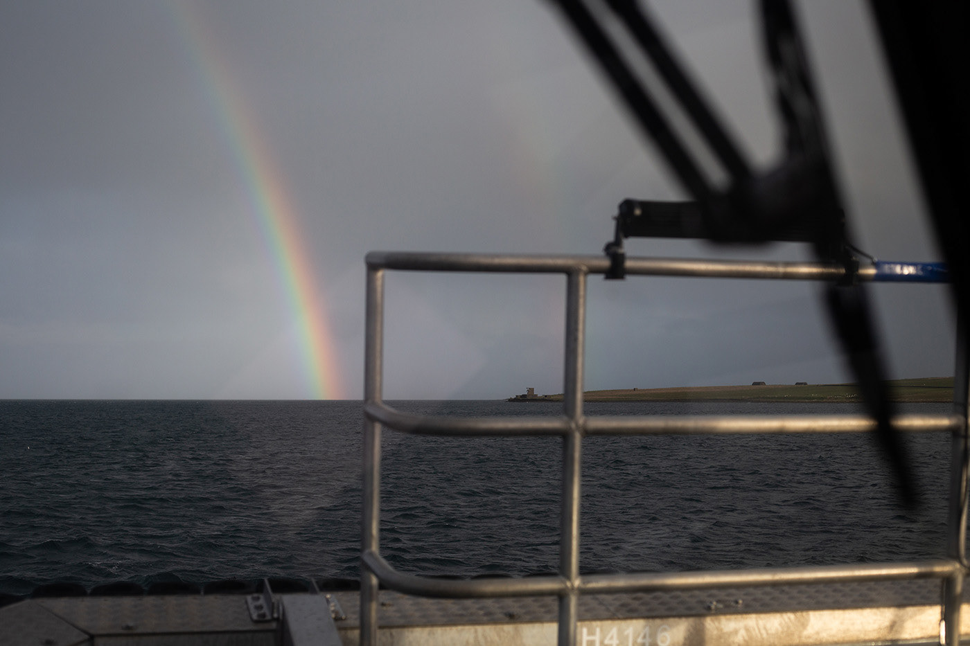 rainbow at sea, seen from through a boat window