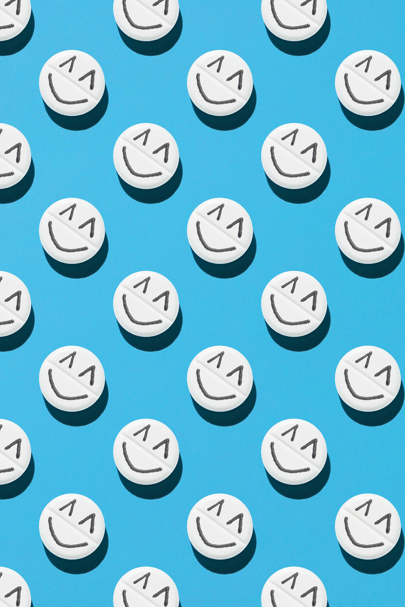 pattern of white pills with emoticon