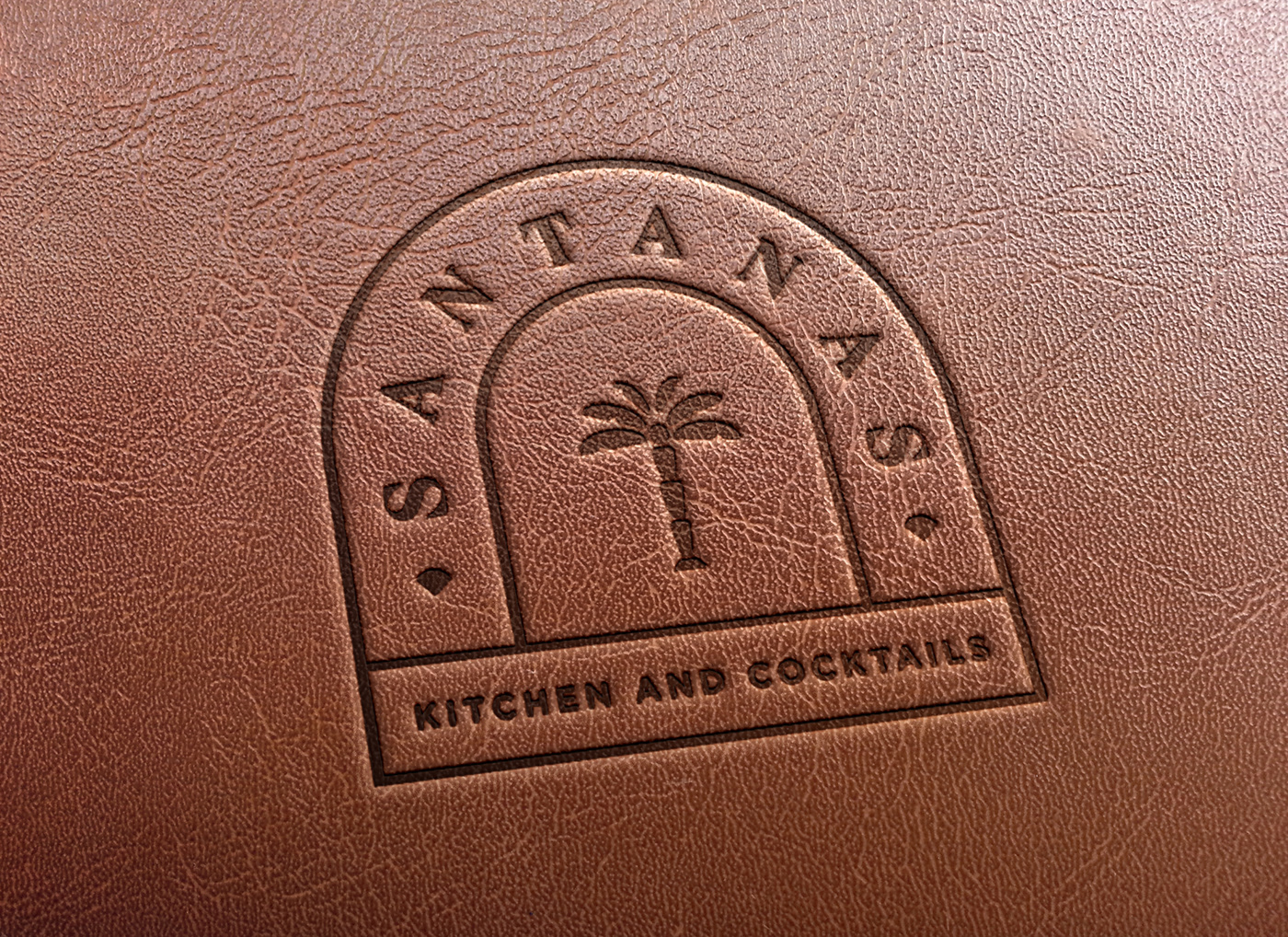Gilded emblem logo of a tropical themed latin restaurant embossed on a leather surface