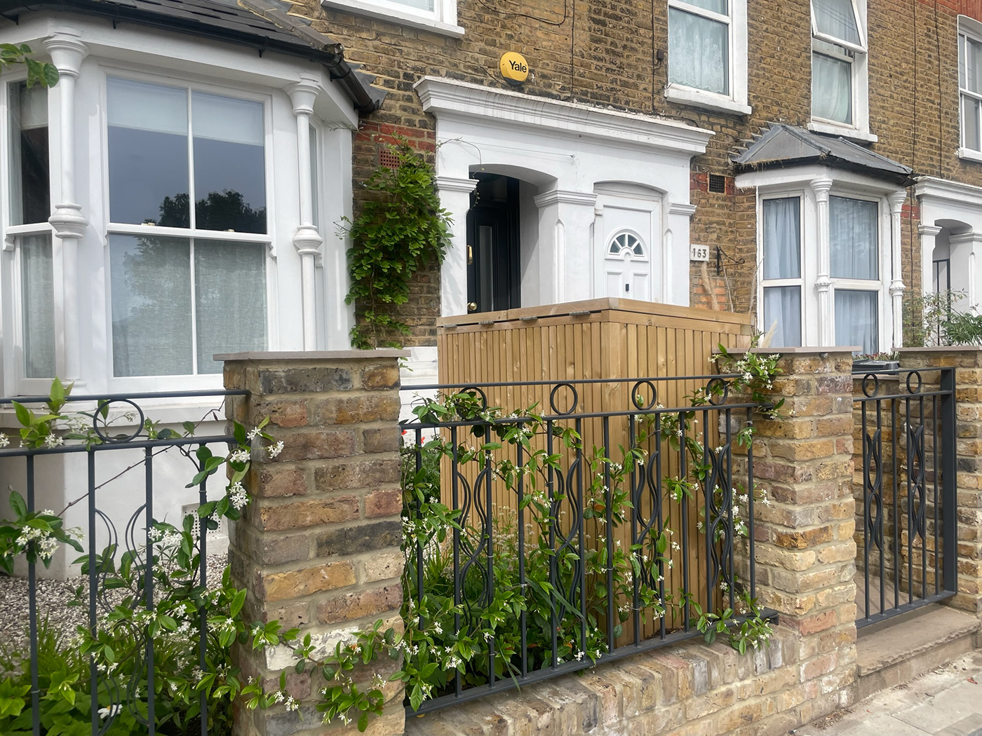 Custom Art Nouveau style railings allow a glimpse into the planting in this redesigned front garden
