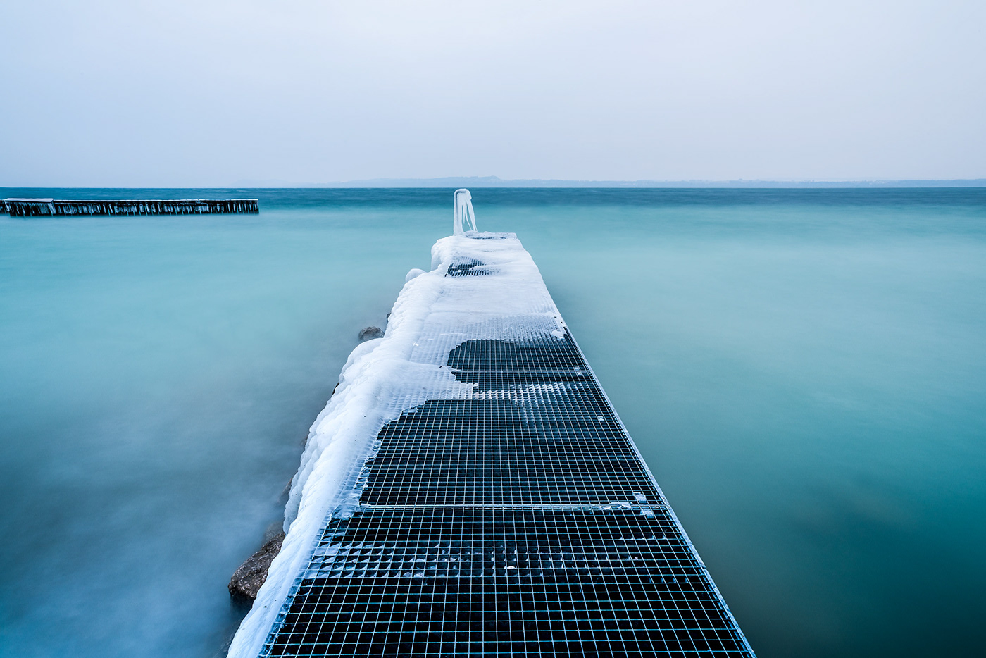 Fine art photography of an icy dock in lake Neuchatel by Jennifer Esseiva.