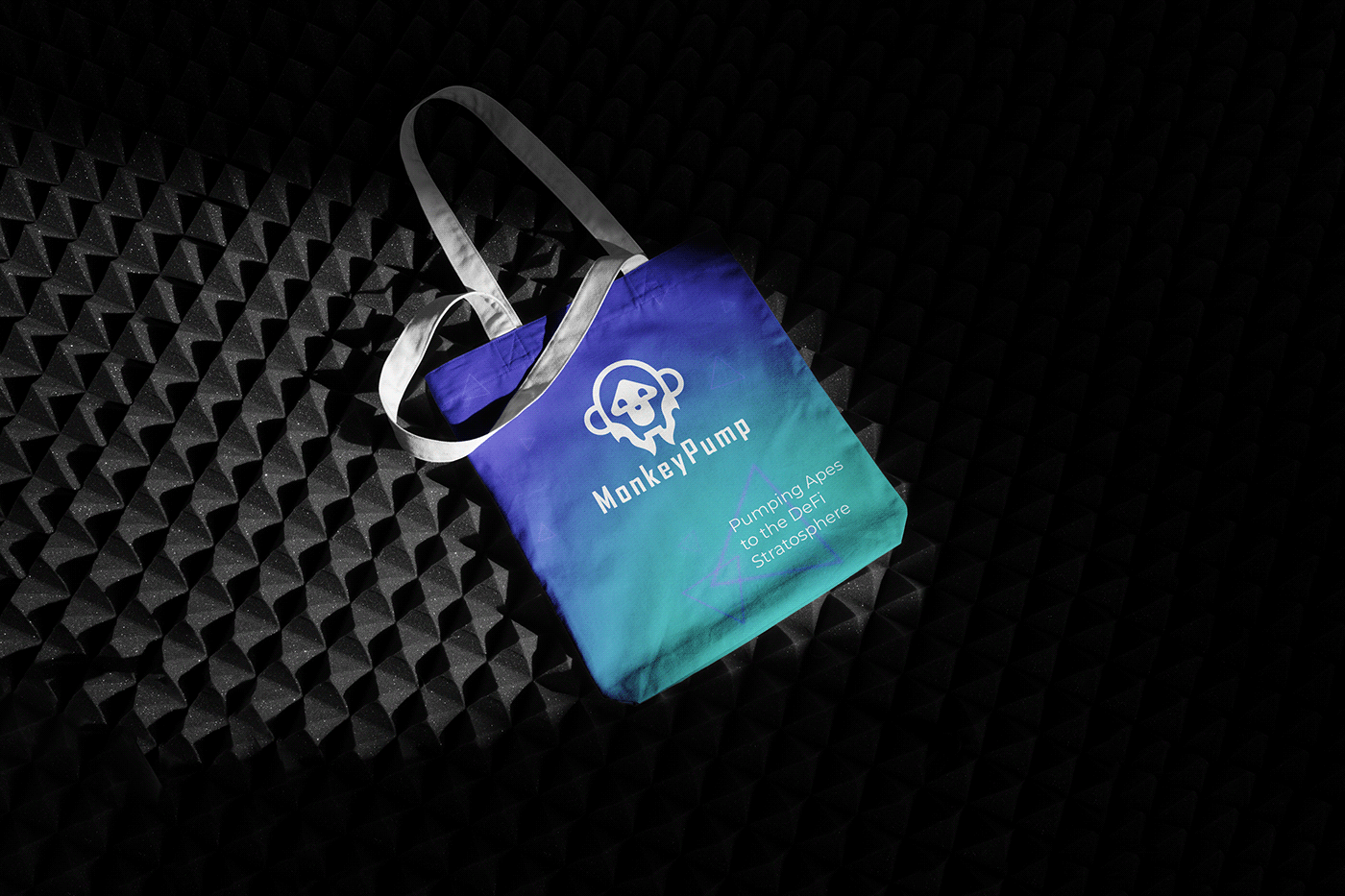 Image of a tote bag with the MonkeyPump logo. Dark background. 