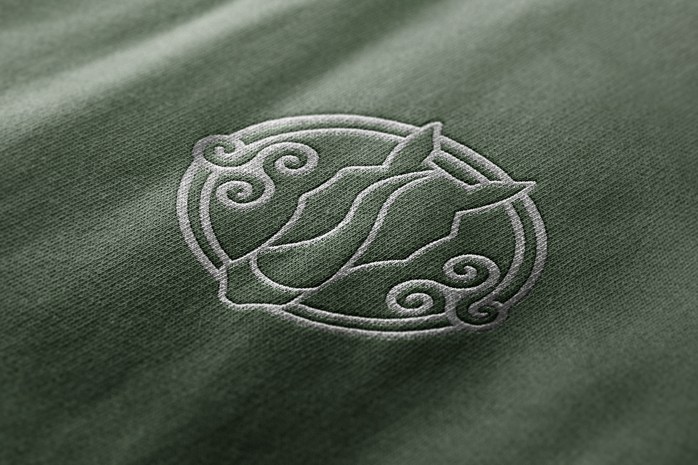 Close-up detail of The Pony Way logo embroidered on a green t-shirt