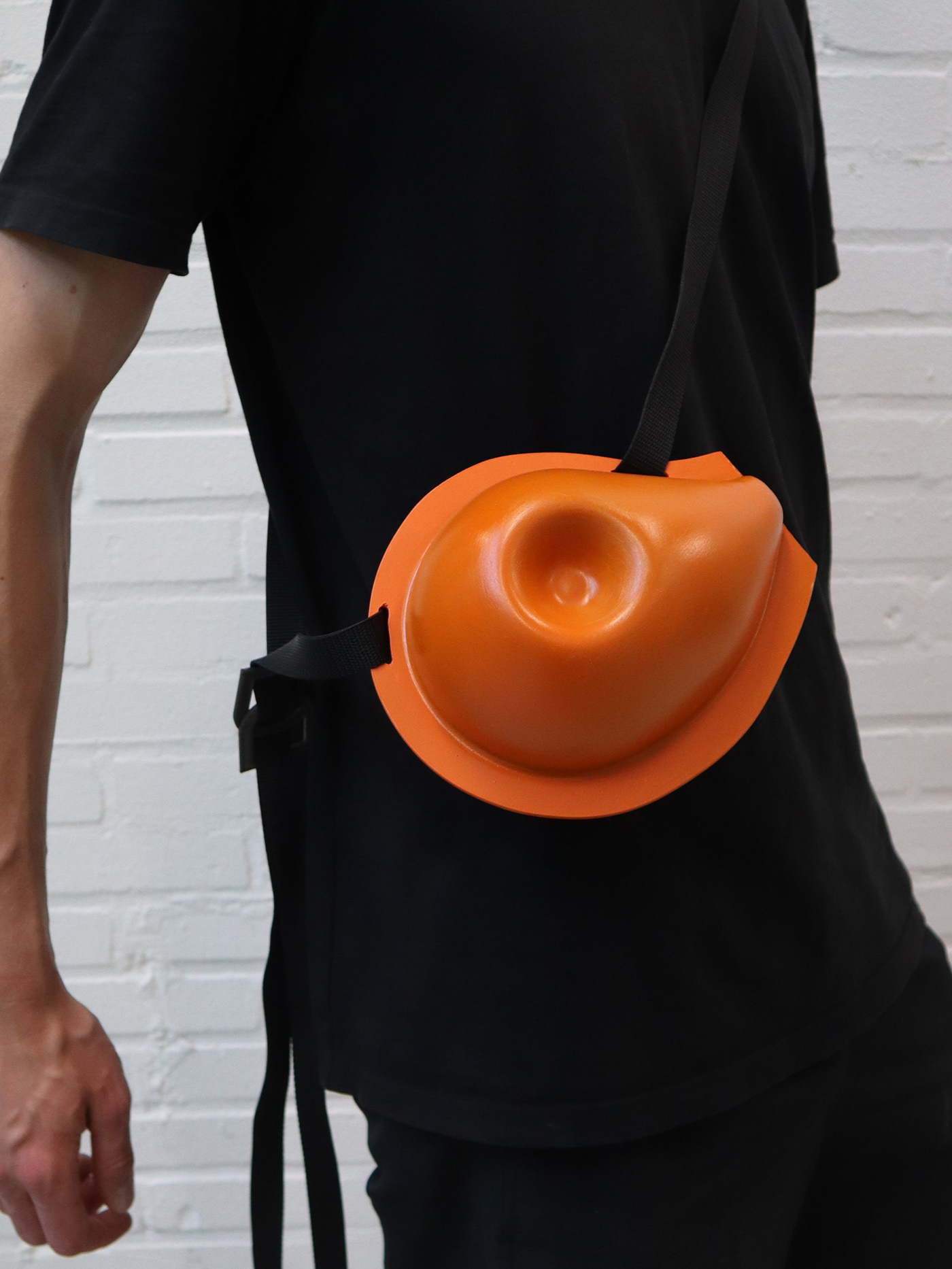A watering can with an adjustable strap for wearing the object around the body.