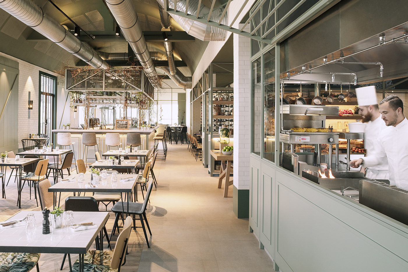 Interior view of CRAFT Market with its open kitchen where chefs are cooking dishes.
