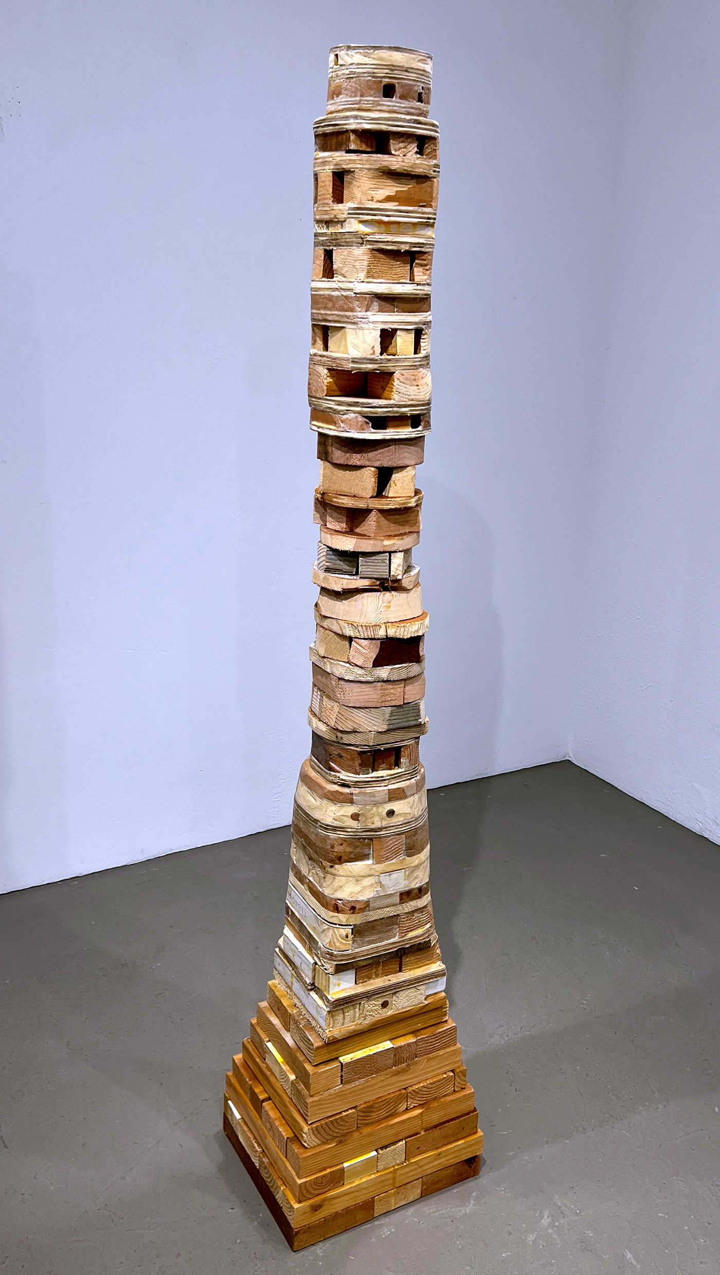 contemporary sculpture made from reclaimed wood stacked and laminated into a column form