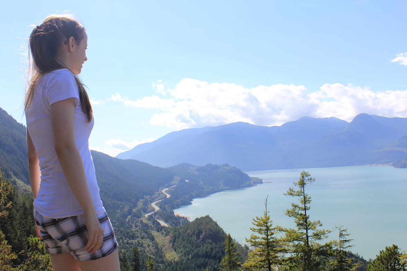Patricia Celan admiring the view of mountains, water, and trees, from a Shannon Falls hike lookout.