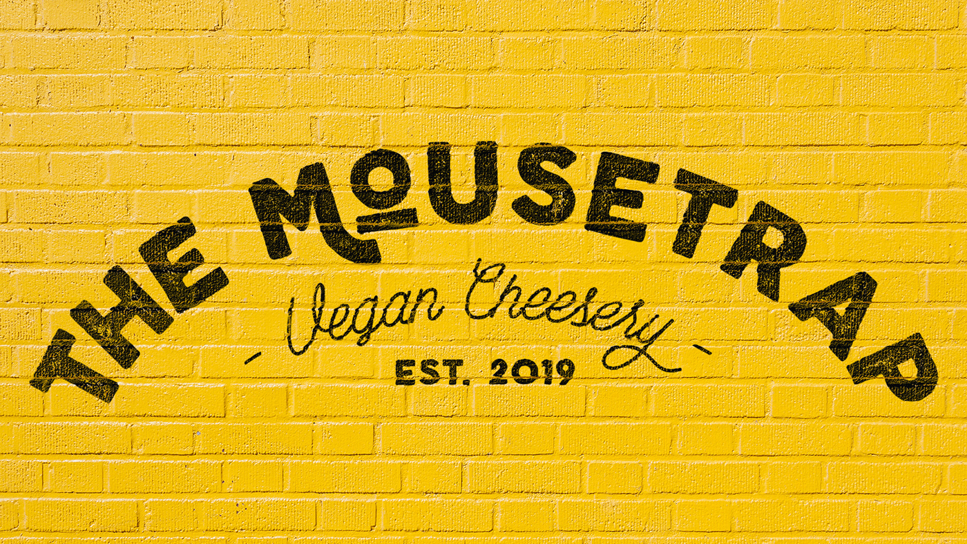 The Moustrap logo on a yellow brick wall