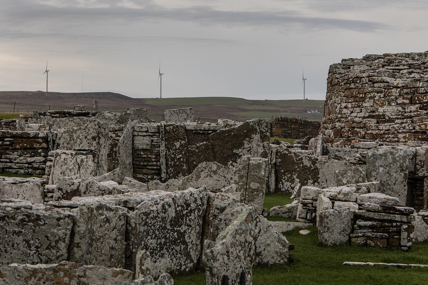 wind turbines on hillside with neolithic ruins in foreground