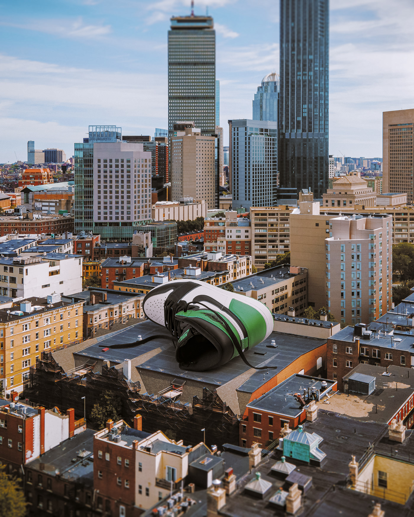 Photo composite of giant sneaker on top of buildings. Retouching using Photoshop