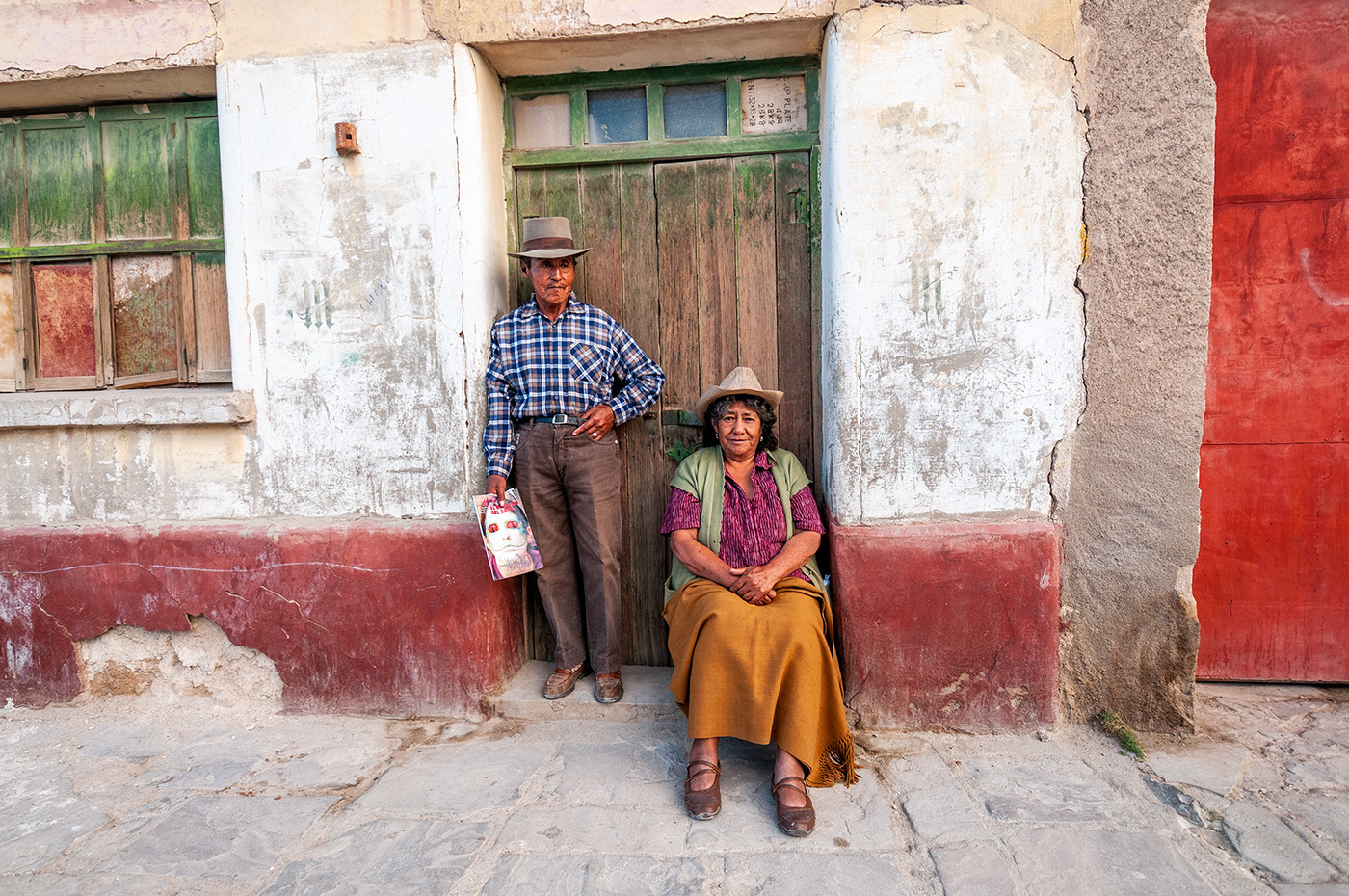 Portrait of a old couple standing in front of their home in Uyuni taken by Jennifer Esseiva.