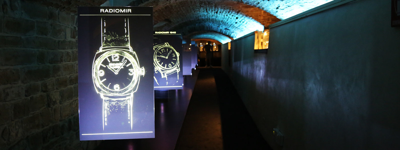 An image of the exhibition, with on the left the graphics depicting the watches of the collection