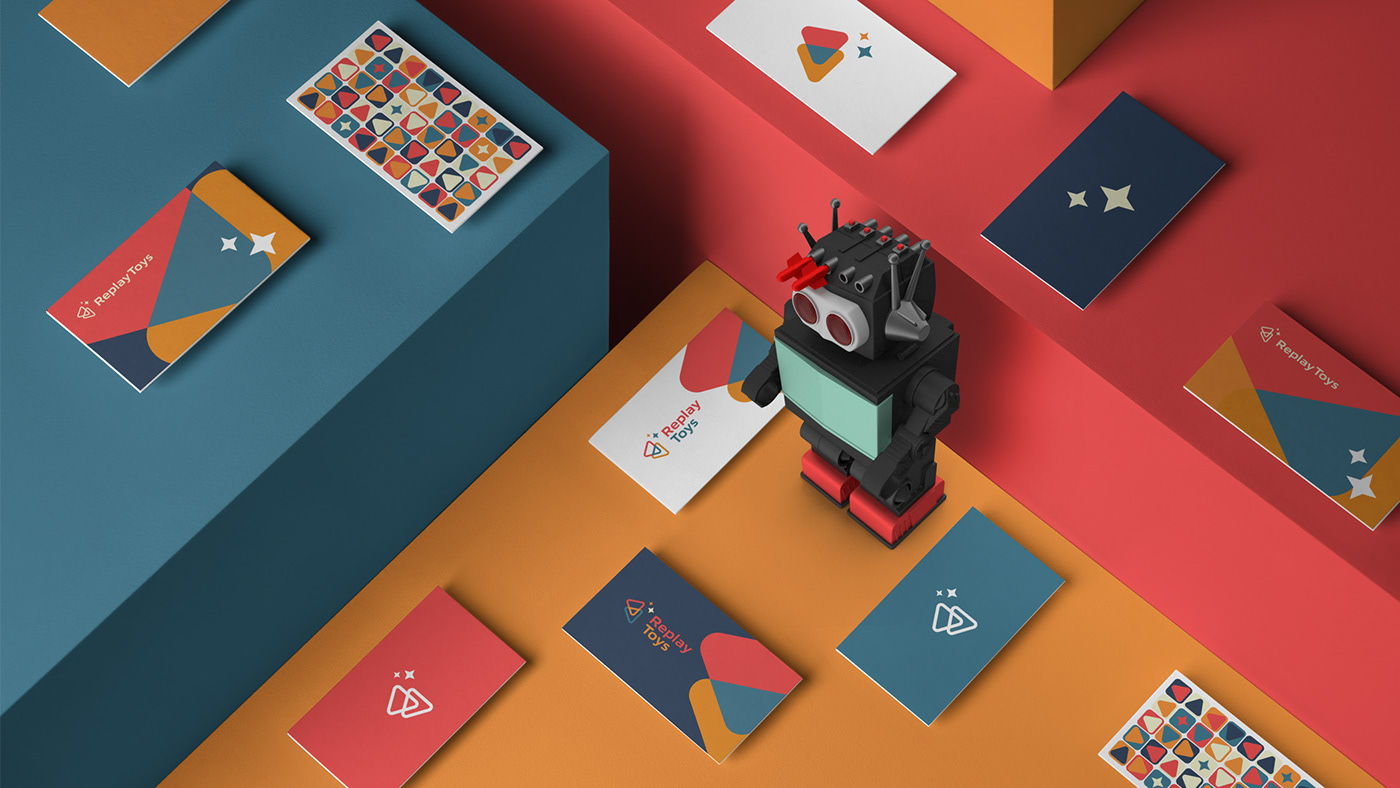 Diferent business cards placed on top of colorful boxes and a retro robot toy