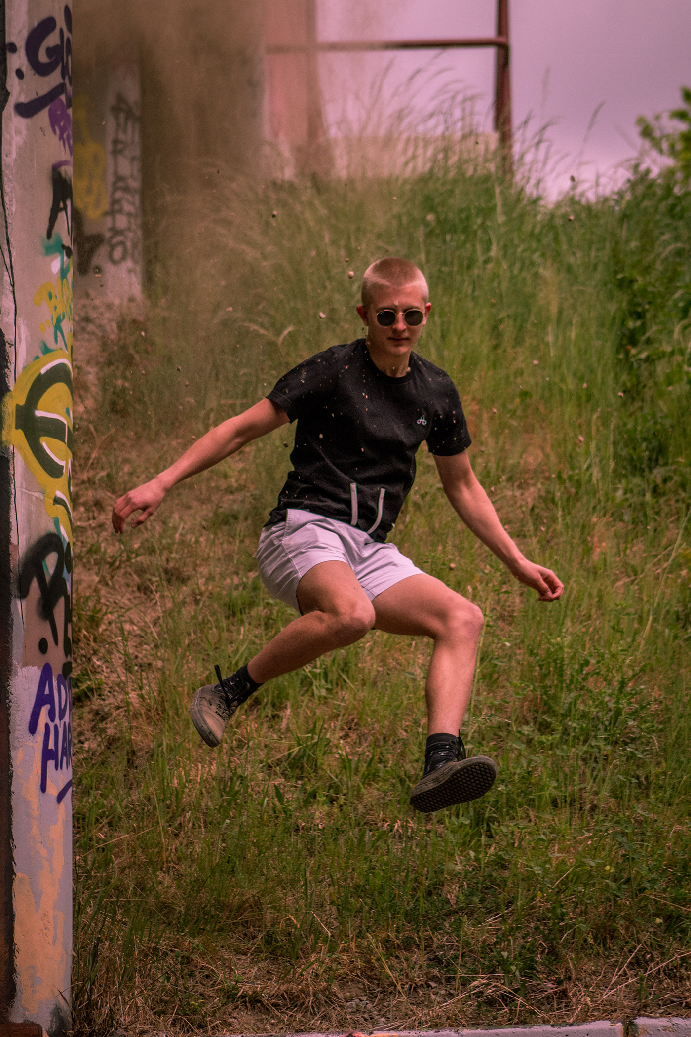 A action shot of a model jumping in the air with dust behind featuring The Uprising tshirt.