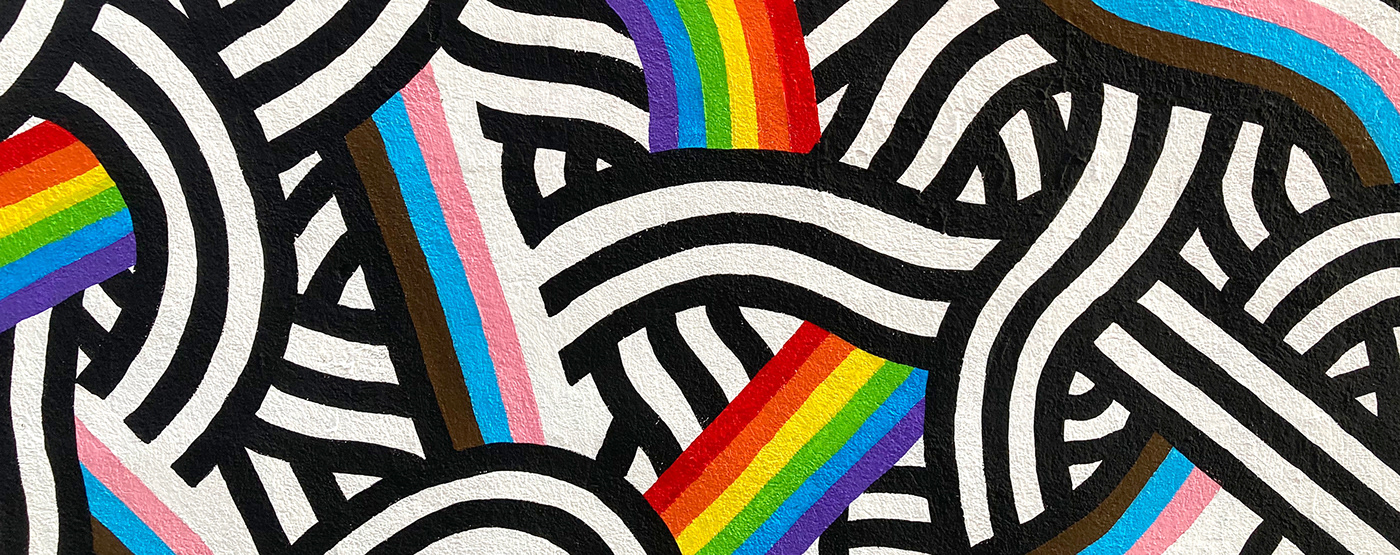 Closeup of a black and white mural with the progress pride flag colors by Stillo Noir