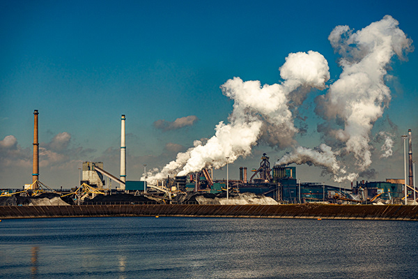 Factory Tata Steel with smoking chimneys on a sunny day, IJmuiden, The  Netherlands Stock Photo