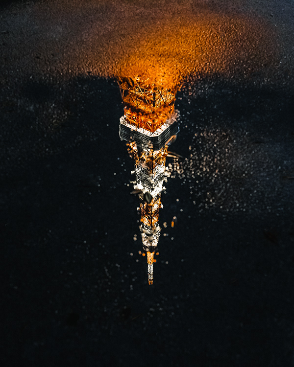 Tokyo Tower reflected in a puddle.