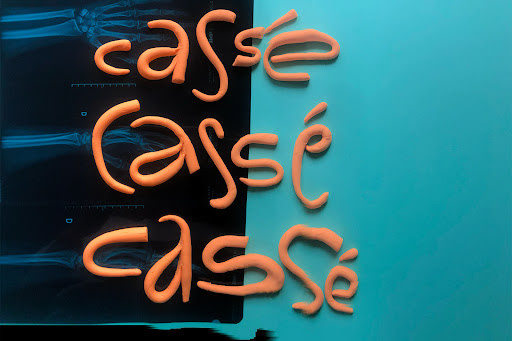 The word cassé, french for broken, in three different sizes, glitched over an xray and colored paper