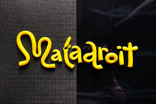The word Maladroit made of clay and animated on a metal grid background