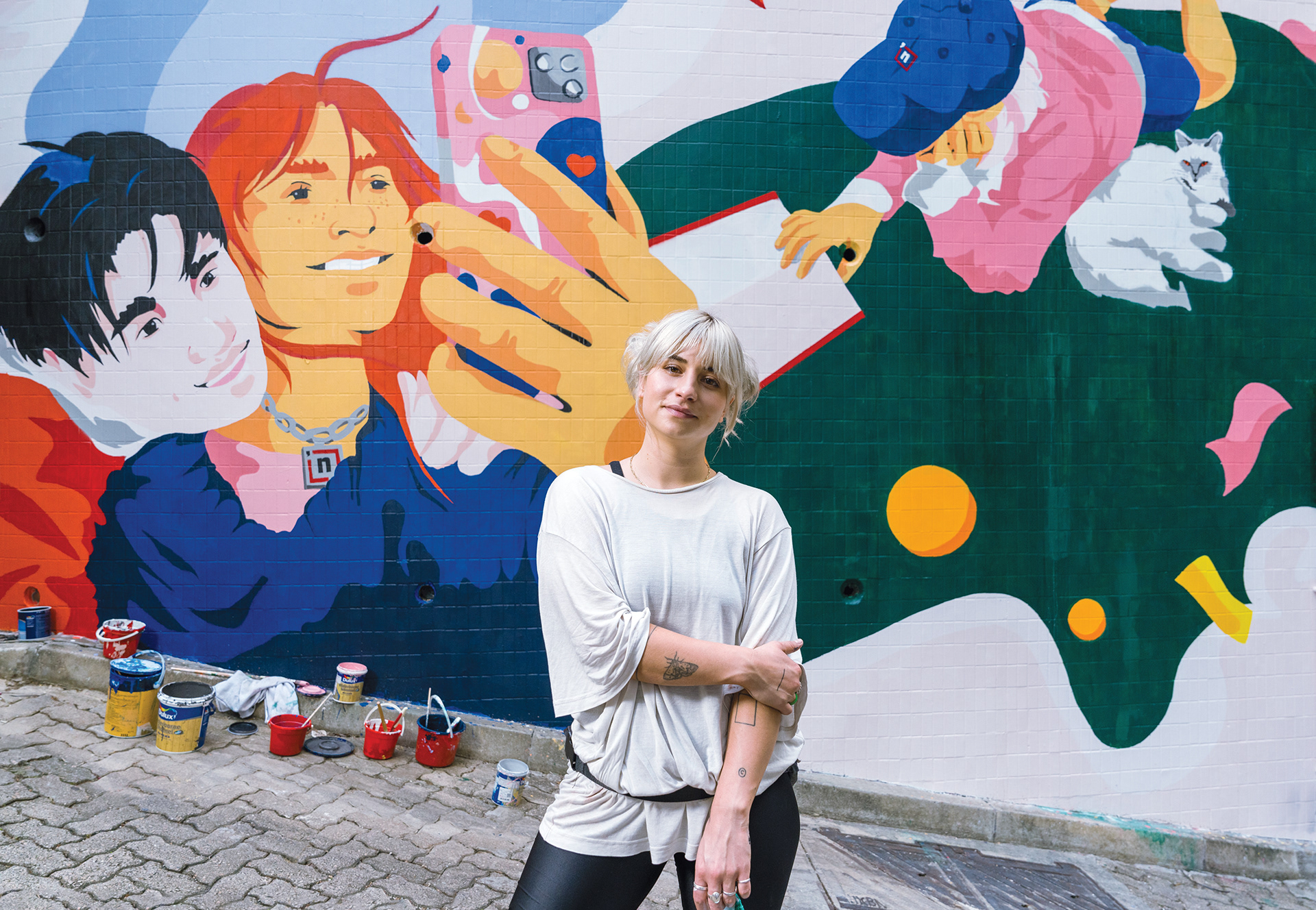 Die Künstlerin Josephine Rais vor ihrem Wandbild in Honk Kong.