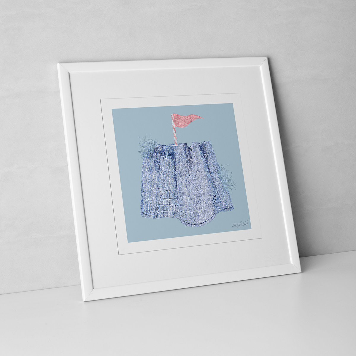 A framed print of a blue sand castle with a pink flag on a delicate blue background.