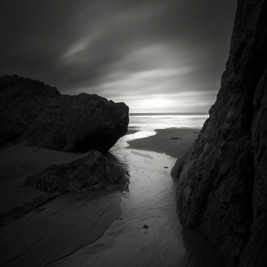 long exposure Ocean sea black and white water rocks sand Streaming clouds light