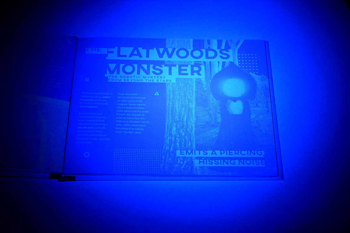 A an open book lit by UV light to reveal information about the Flatwoods Monster