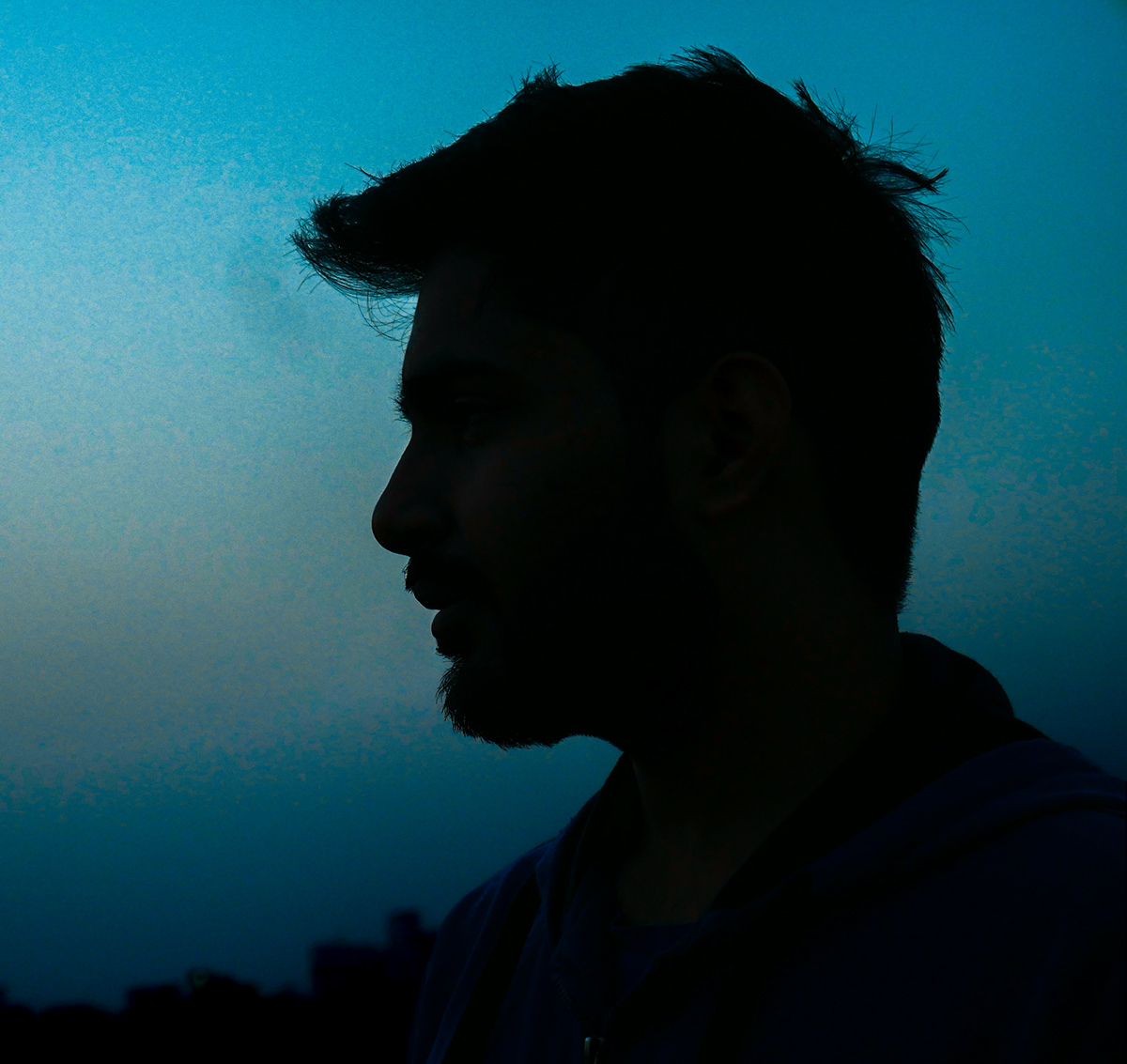 a person in a silhouette form in the blue hour alone