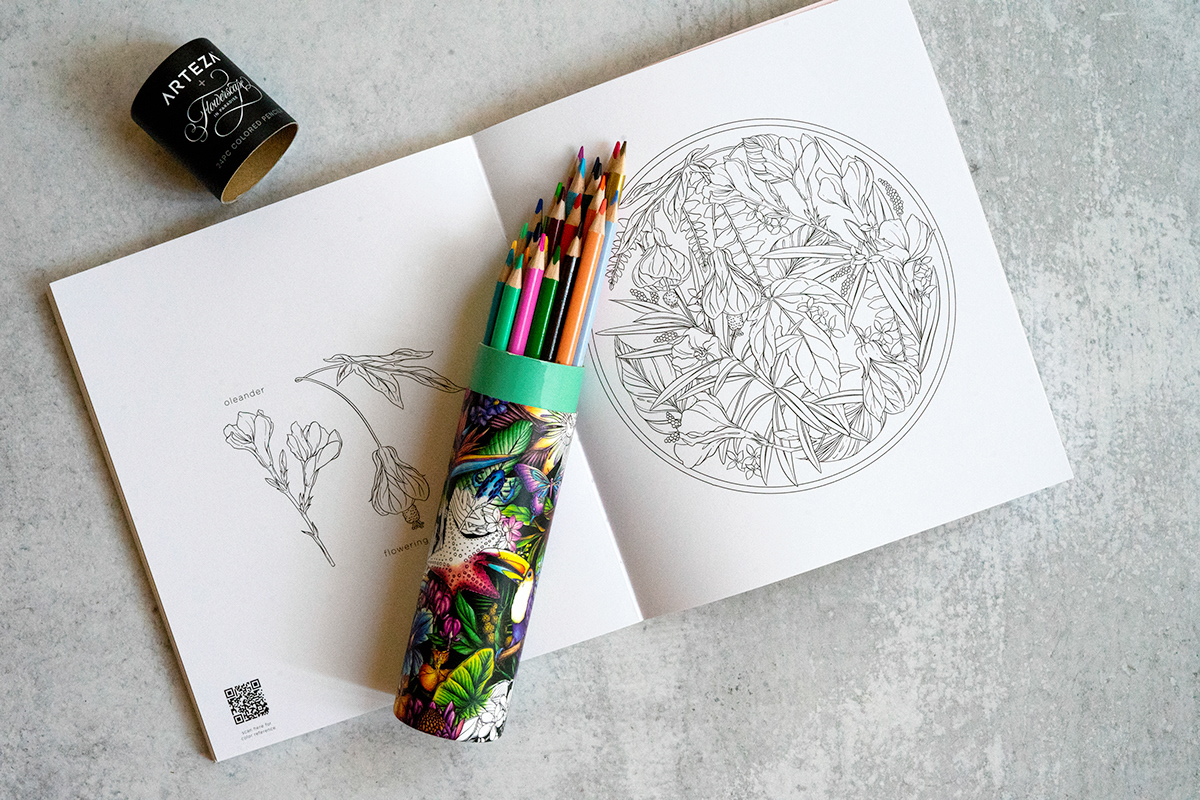 image of open Flowerscape coloring book with colored pencil set resting on top.