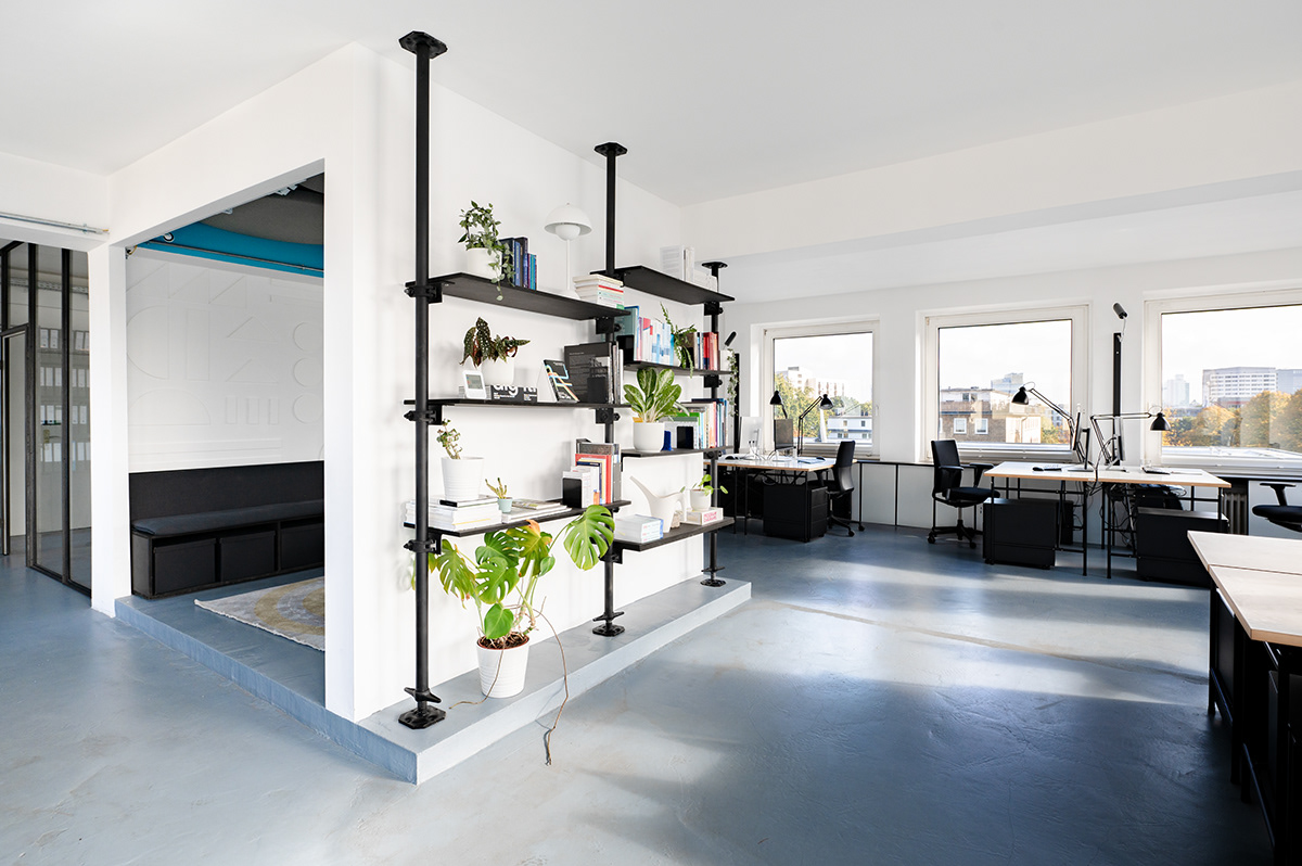 Bright modern office space with bookshelf and room-in-room construction