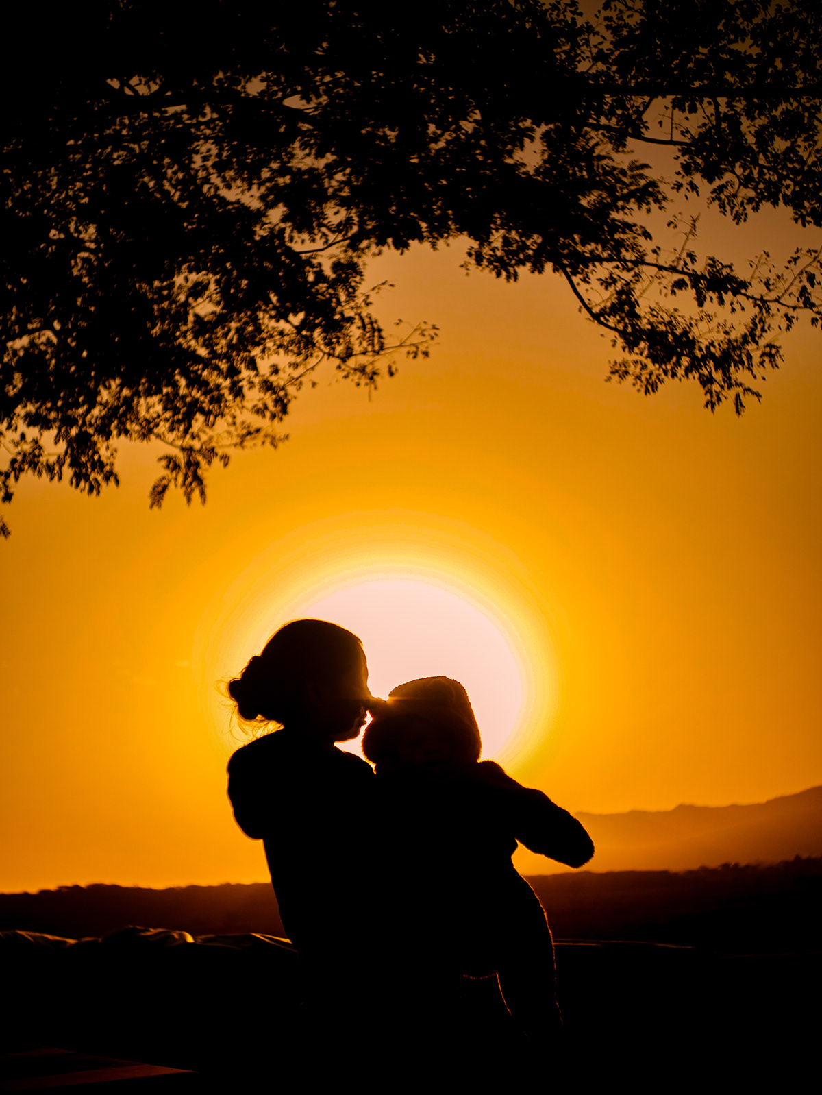 A mother with her daughter at the sunset 