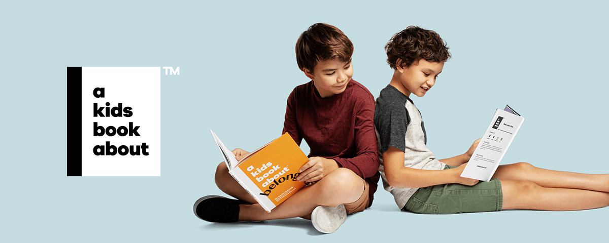 A marketing image showing two boys reading A Kids Book About™ books 