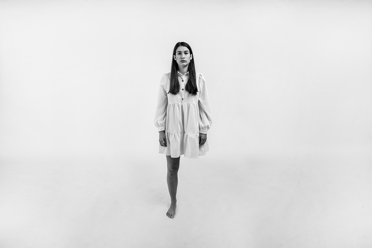 woman in white coat standing on gray scale