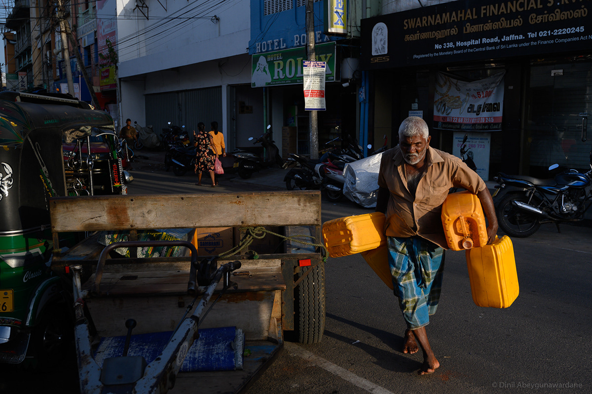A man unloading cans from a tractor - Jaffna - Sri Lanka