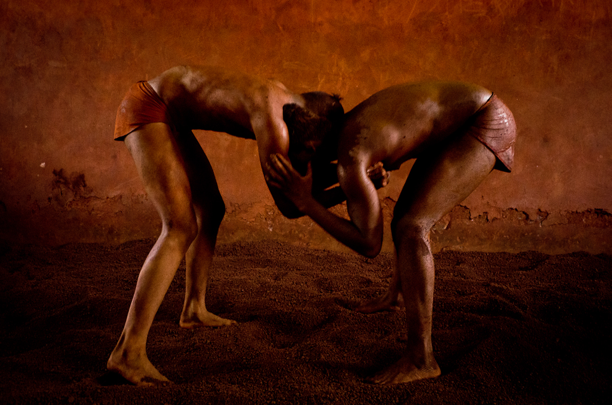 India Kolhapur Kushti wrestlers Wrestling men bodies orange mud clay dirt red sport Ancient tradition group belief massage dirty skin Celibacy