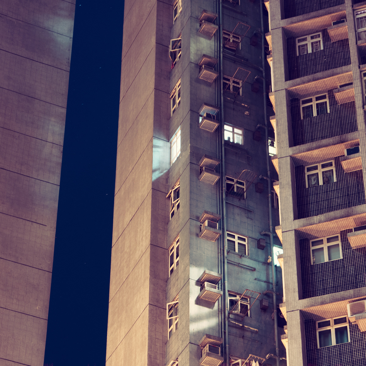 Night view of an apartment building with glowing windows. Hong Kong